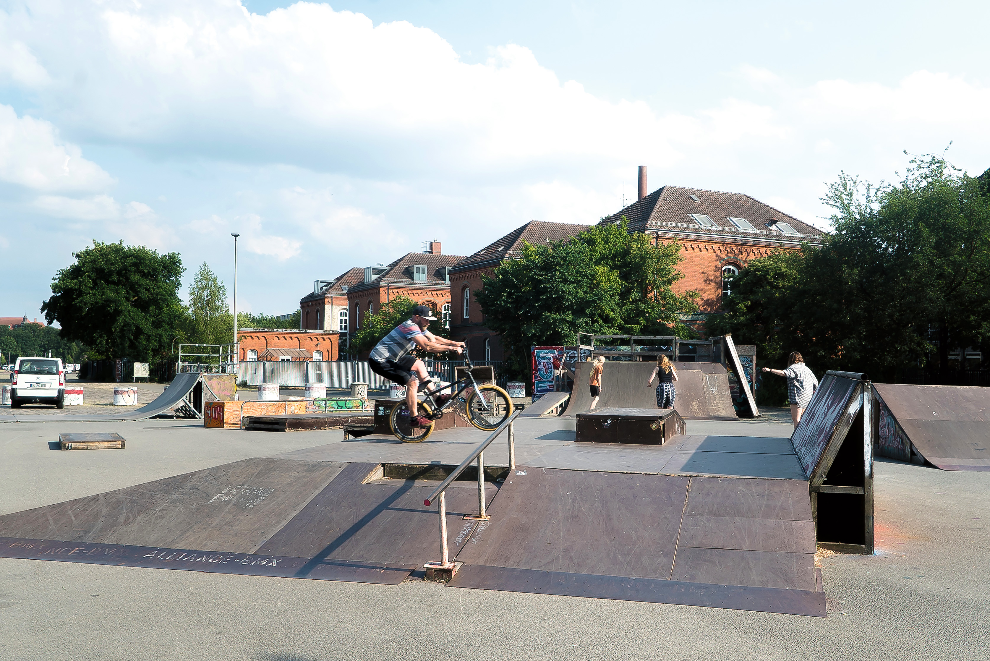 Auf dem Skaterplatz vor dem Kulturzentrum Schlachthhof f&auml;hrt ein BMX-Fahrer &uuml;ber eine Rampe. Im Hintergrund fahren drei Skaterinnen.
