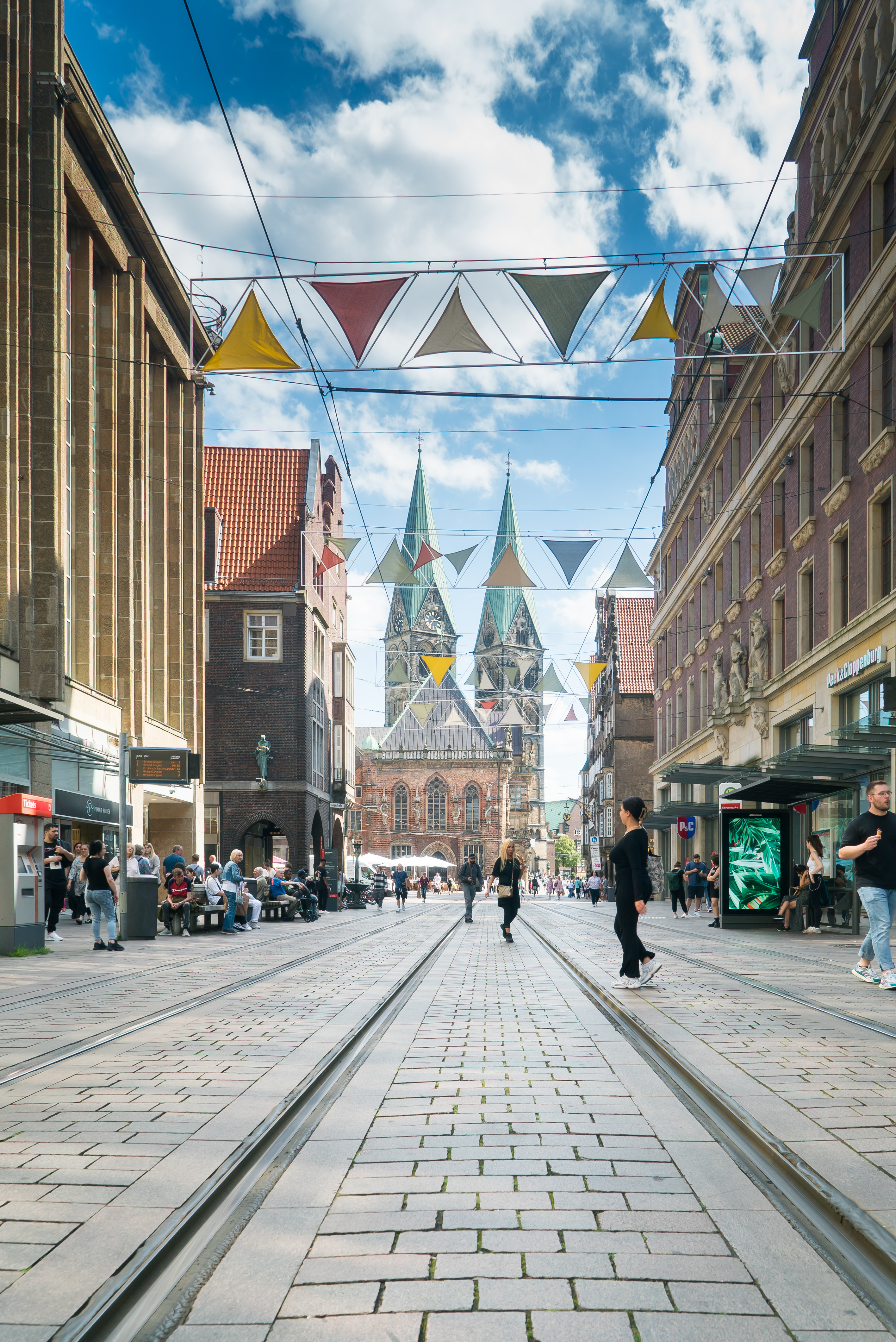 Die Obernstra&szlig;e im Zentrum von Bremen mit Gesch&auml;ften links und rechts, dem Dom im Zentrum und einer bunten Girlande &uuml;ber der Stra&szlig;e.